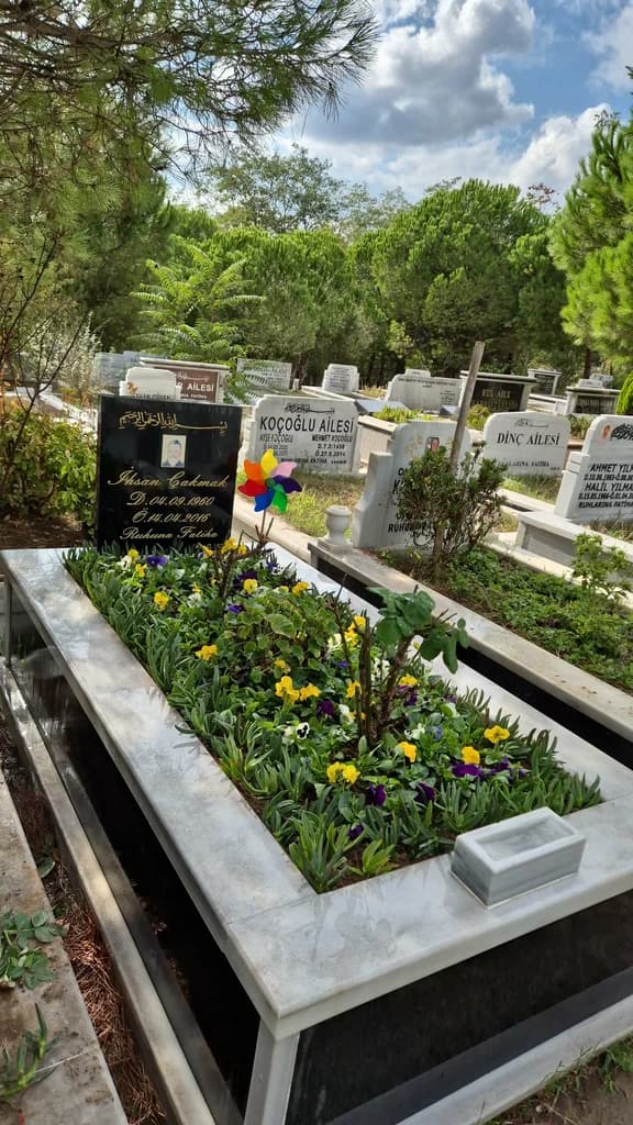 Mezar taşı ve çiçek düzeni